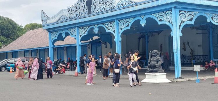 Wisatawan memanfaatkan momentum liburan untuk mengunjungi obyek wisata bersejarah Keraton Kasunanan Surakata Hadiningrat dengan foto di depan Kori Kamendungan. (Foto: Mulato Ishaan)