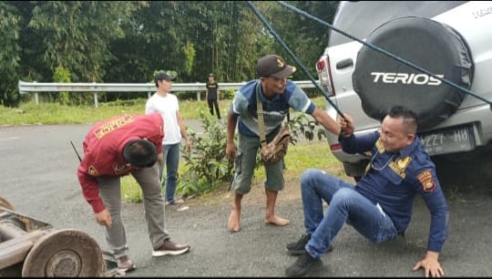 personel Satres Narkoba Polres Pagaralam membantu warga yang kendaraan roda empat miliknya terperosok ke dalam selokan, Minggu (12/12/2022)