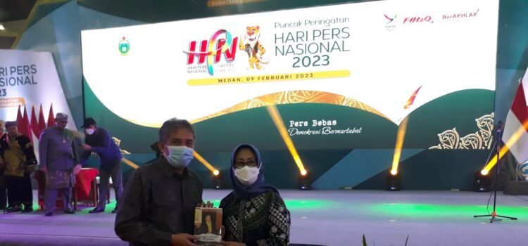 Maspriel Aries saat memberikan buku Maspril Aries Terbitkan Buku “Belajar Jurnalistik ke Missouri”